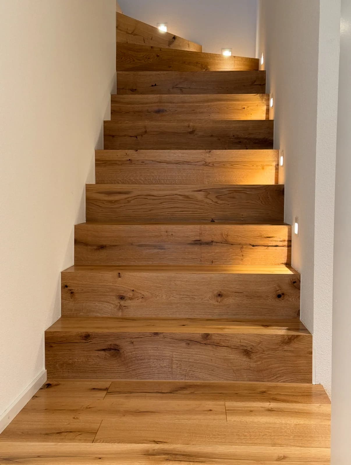 Eichenholztreppe mit seitlich integrierter warmer LED-Beleuchtung